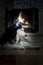Dog by the fireplace. Portrait Siberian husky dog lies by the burning fireplace, night.