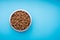 Dog food in a metal bowl. Blue background