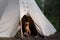 Dog in the forest on the background of the wigwam. Camping with a pet.