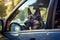 A dog of the German Shepherd breed sits behind the wheel of a car. Travelling with pets