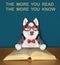 Dog husky intelligent reads book at desk