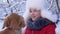 Dog kisses the hostess. dog licks girl`s face. Beautiful girl smiles, caresses her beloved dog in winter in park. girl