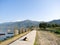 Dog laying down for sunbathing on the path around the lake