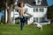 Dog with leash on ground running from his handler. Portrait of a little boy on a background of green backyard lawn in an