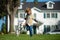 Dog with leash running with handler. Little boy on a background of green backyard lawn in an summer sunny day. Little