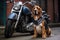 dog with a leather vest sitting next to a parked motorcycle