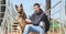 A dog and a man, a German shepherd and a young man walk on a sunny day