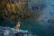 dog in the mountains lake . Nova Scotia Duck Tolling Retriever on peak of rocks at sunset. . Hiking with a pet