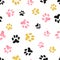 Dog paw print seamless pattern in pink, black and golden colors