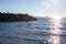 A dog plays fetch in the ocean off of Ambleside Dog Beach