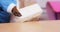 Dog puts plastic container on wooden table, close up, front view.