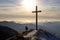 Dog silhouette near a cross on the top of the mountain