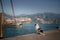 The dog is sitting on the pier. Embankment in Italy, Lake Garda. Marble Australian Shepherd. Travel