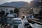 The dog is sitting on the pier. Embankment in Italy, Lake Garda. Marble Australian Shepherd. Travel