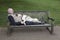 Dog sleeps on man who lies on park bench in london st james`s pa