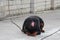 A dog tied to a chain lies and licks his nose with a pink tongue. Rottweiler