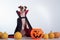 Dog in a vampire cloak and jack-o-lantern on a white background. Halloween Jack Russell Terrier in Count Dracula costume