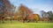 Dog walking in a park - young couple and their Labrador in North Inch park in Perth, Scotland. Autumn in a park