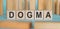 Dogma word written on wooden cubes on background