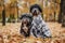 Dogs for a walk in the form of an old man and an old woman. Dogs in wigs, glasses and scarves in the autumn park.