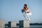 Doing squats on the cement cube. Shot of sportive woman doing fitness exercises near the lake at daytime