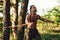 Doing workout. Handsome shirtless man with muscular body type is in the forest at daytime