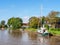 Dokkumer Ee canal with sailboat and bridge in Burdaard in Friesland, Netherlands
