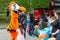 The doll of big growth in the form of an orange bird, the symbol of the Dodo pizzeria-pizza, is photographed with children at the