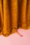 Doll leg with ballet dancer slipper shoe hiding behind a golden theater curtain. Creative minimal concept with pastel pink