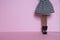 Doll legs and striped skirt on pink background