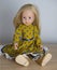 Doll with long blond hair in smart clothes, in ayellow dress and boots, concept children`s toy, doll fashion, hobby, for girls,