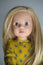 Doll with long blond hair in smart clothes, in ayellow dress and boots, concept children`s toy, doll fashion, hobby, for girls,