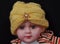 Doll wearing light yellow handknitted turban cap