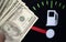 Dollar bills against oil mileage dashboard background