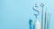 Dollar sign of toothpaste. Tube of colored toothpaste and a toothbrush and dentist tools, a mirror, a hook on a blue