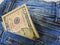 Dollars in a jeans pocket, closeup.A few bills of one hundred dollars stick out of the back pocket of jeans.finance