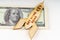 On the dollars lies a wooden model of a rocket with the inscription - Get More Done