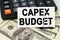 On the dollars there is a calculator and a business card with the inscription - CAPEX BUDGET