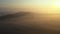 Dolly move in aerial view of early morning mist floating over landscape