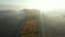 Dolly move in aerial view of early morning mist over traffic among forest trees
