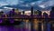Dolly night time panorama of Brisbane city with purple lights on Story Bridge