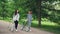 Dolly shot of beautiful young girls African American and Caucasian walking in park along path with bikes and talking