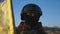 Dolly shot of girl in military helmet and balaclava holds a waving national flag. Female soldier of ukrainian army