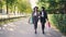 Dolly shot of happy girls shopaholics walking in the street carrying shopping paper bags and talking discussing new