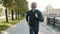 Dolly shot of mature sportsman jogging and smiling enjoying healthy activity outdoors