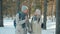 Dolly shot of senior couple man and lady walking in park on winter day talking