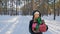 Dolly shot of surprised teenage girl playing with gift in snowy forest