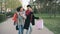 Dolly shot of two attractive mixed race women dancing and have fun while walking down the park with shopping bags. Happy