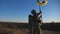 Dolly shot of woman and man in military uniform lifted flag of Ukraine against sunset. Female and male soldier of