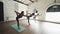 Dolly shot of yoga students doing lord of the dance pose standing barefoot on colorful mats. Women are wearing trendy